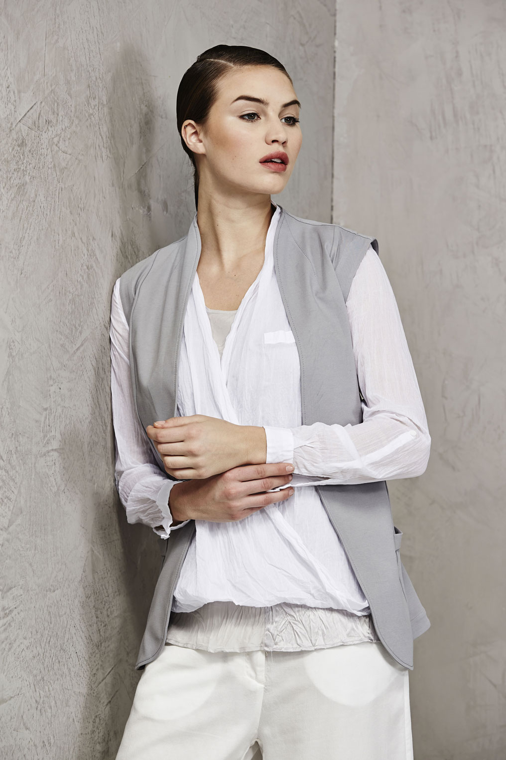 This model wears a jersey cotton waistcoat and a blouse in crumpled voile cotton